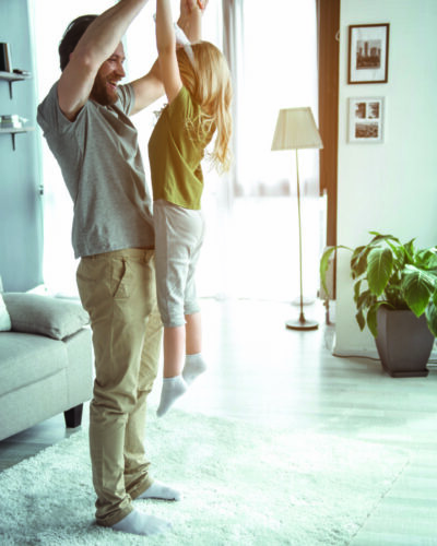 Excited dad is playing with his child at home